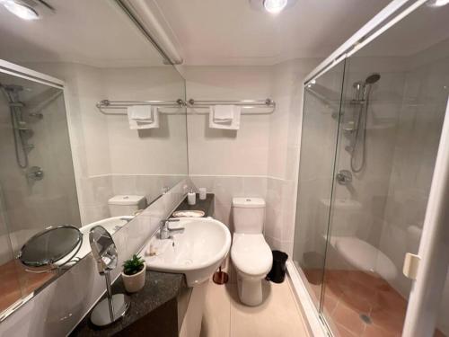 a bathroom with a toilet and a sink and a shower at Luxurious 2-Bed with Alfresco Balcony & Parking in Brisbane