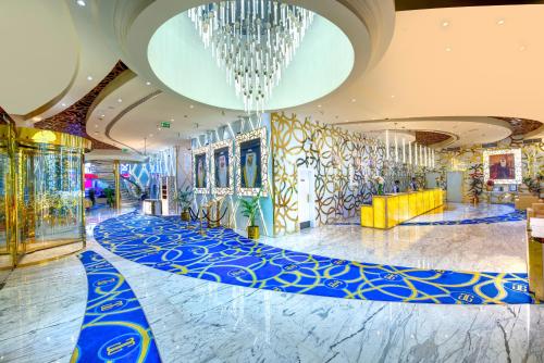 a lobby with a blue carpet and a chandelier at Gevora Hotel in Dubai