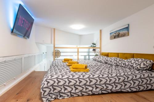een kamer met een bed met gele kussens en een tv bij Studio Apartment LION Portorose in Portorož