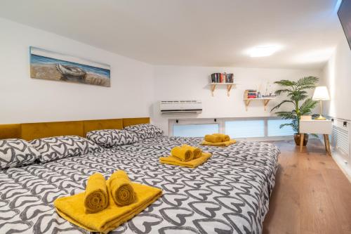 een slaapkamer met een bed met gele handdoeken erop bij Studio Apartment LION Portorose in Portorož
