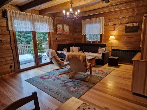 een woonkamer met een bank en stoelen in een hut bij Domki Brenna Leśnica chatka ze spa in Brenna