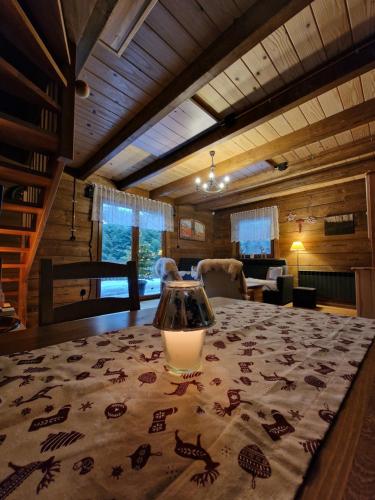 a dining room with a table with a candle on it at Domki Brenna Leśnica chatka ze spa in Brenna