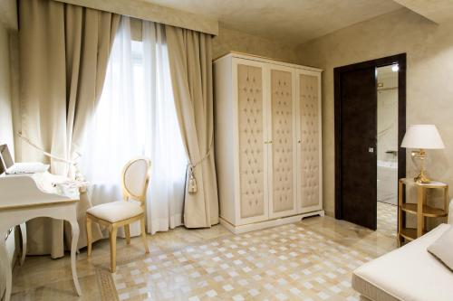 a bedroom with a white desk and a white dressing table at Best Western Premier Milano Palace Hotel in Modena