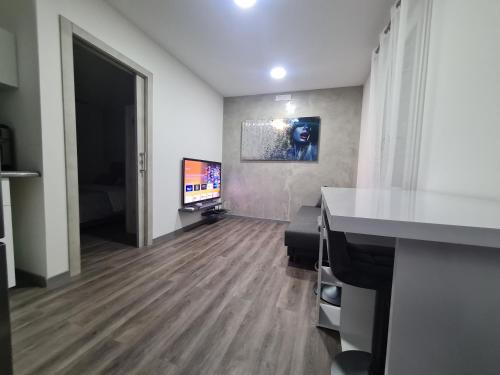 una stanza vuota con televisore e una stanza con pavimento in legno duro di Apartment Udine a Udine