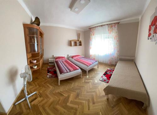 - une petite chambre avec 2 lits et une fenêtre dans l'établissement Edina apartman, à Balatonlelle