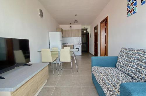 uma sala de estar com um sofá azul e uma cozinha em F1 2 St Julians, Private room, bathroom & living shared em St Julian's