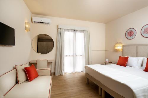 ザンブローネにあるVOI Le Muse Essentiaの大きなベッドとソファが備わるホテルルームです。