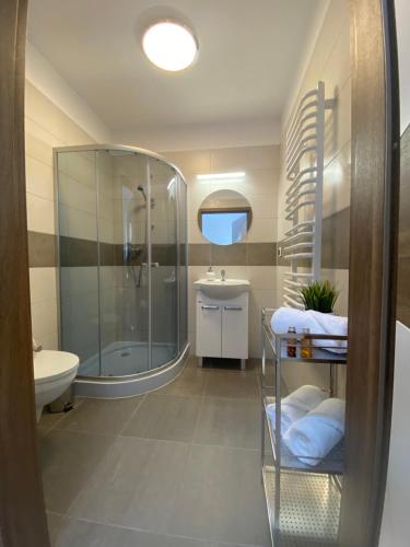 uma casa de banho com um chuveiro, um WC e um lavatório. em Apartamenty Cechowianka Ustka em Ustka