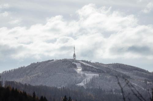 a hill with a radio tower on top of it at Przepiękny apartament ORANGE z widokiem na Skrzyczne - Sun&Sport in Szczyrk