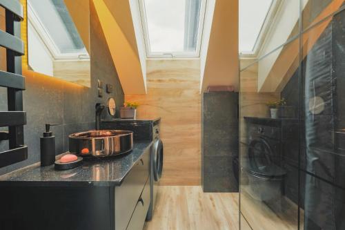 a kitchen with a stove and a sink in a room at Przepiękny apartament ORANGE z widokiem na Skrzyczne - Sun&Sport in Szczyrk