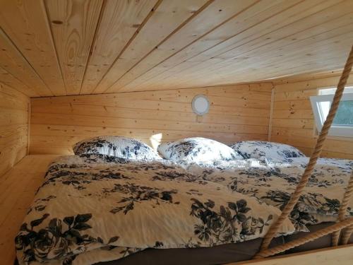 a bed in a room with a wooden ceiling at Glamping sever in Mikulášovice