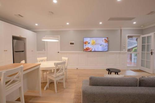 a living room with a table and a tv on the wall at Tanglewood in Vermont South