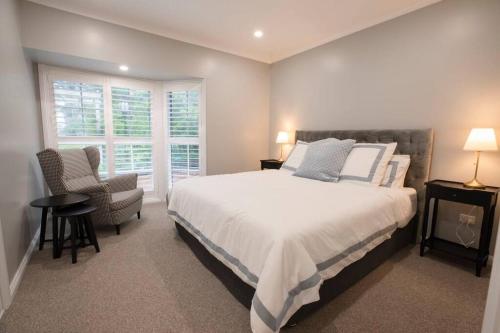 a bedroom with a bed and a chair and a window at Tanglewood in Vermont South