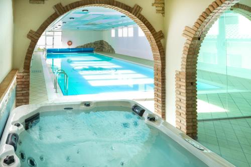 - une grande piscine avec une arche dans un bâtiment dans l'établissement Hotel Residence Panorama La Forca, GTSGroup, à Tignale
