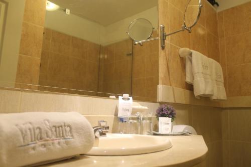 a bathroom with a sink and a mirror at Hotel Vila Santa in Lima