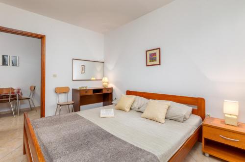 sypialnia z łóżkiem, biurkiem i krzesłem w obiekcie Apartment Luana A2 w Fažanie