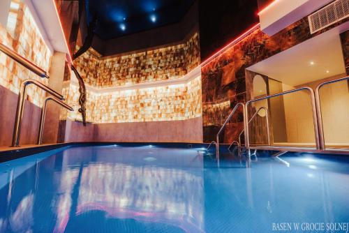 a swimming pool in a hotel room with a bar at Hotel Era in Świeradów-Zdrój