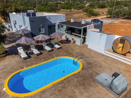 una vista aérea de una casa con piscina en Old olive tree cottage en Áyioi Apóstoloi