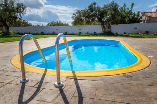 a small swimming pool with two metal bars around it at Old olive tree cottage in Áyioi Apóstoloi