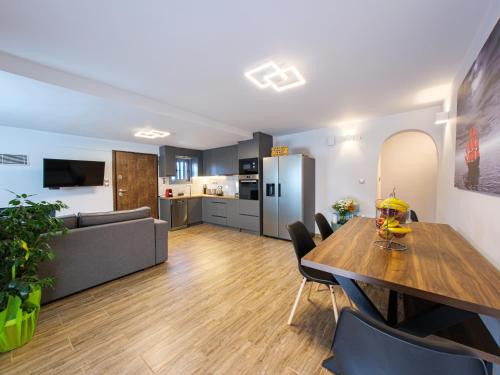 a living room with a dining table and a kitchen at Old olive tree cottage in Áyioi Apóstoloi