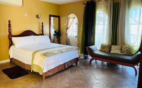 a bedroom with a bed and a chair in it at Kris’o Super Studio in Ocho Rios