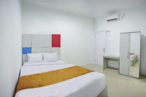 a bedroom with a large bed and a bathroom at Ndalem Kraton Hotel in Sidoarjo