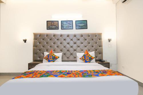 - une chambre avec un grand lit blanc et des oreillers colorés dans l'établissement FabHotel Radiant Inn DLF Phase 3, à Gurgaon