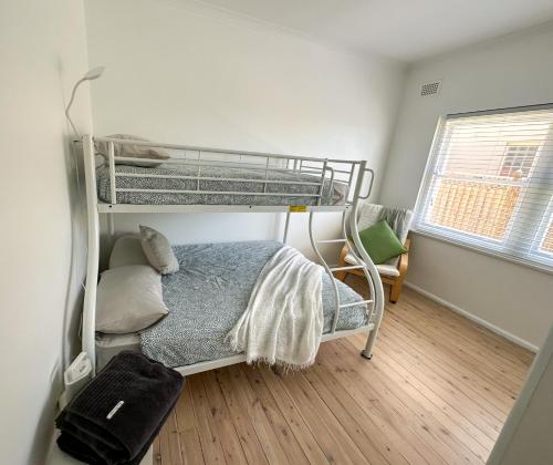 a bedroom with two bunk beds and a window at Esplanade Bliss in Cronulla