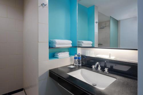 a bathroom with a sink and a mirror at Hotel Santika Bogor in Bogor