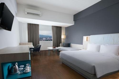 Postel nebo postele na pokoji v ubytování Hotel Santika Bogor