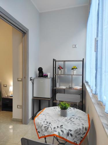 a room with a table and a refrigerator at Apartment NAPOLI MARADONA in Naples