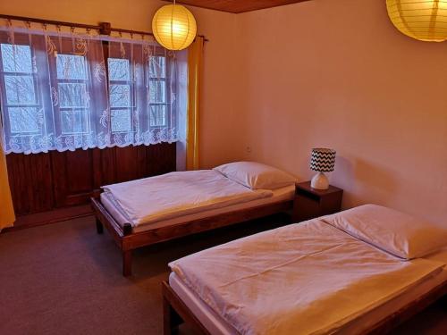 two beds in a bedroom with a window and two lamps at Golden View Villa - Great place for vacations in Przesieka