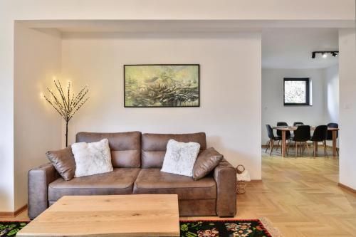 a living room with a brown couch and a table at Bellevue Bjelasnica in Bjelašnica