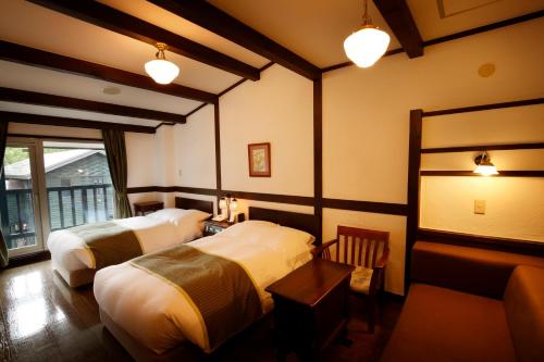a hotel room with two beds and a window at Hotel Jogakura in Aomori