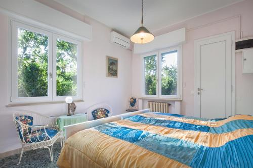 een slaapkamer met een bed en 2 ramen bij Villa Belvedere-Con piscina a Bardolino in Costermano
