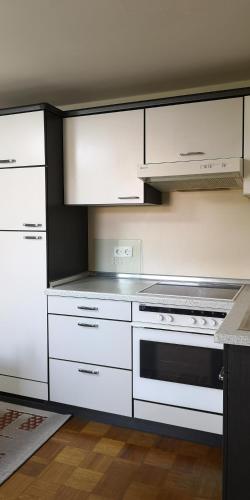 a kitchen with white cabinets and a stove top oven at Vermietung Gisl in Wiesent