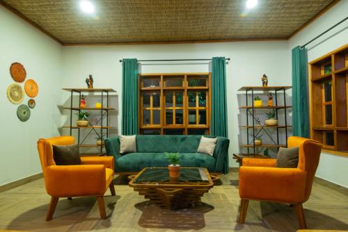 a living room with a green couch and orange chairs at Gorilla Leisure Lodge in Kisoro