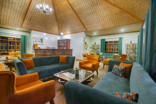 una sala de estar con sofás azules y sillas naranjas. en Gorilla Leisure Lodge en Kisoro