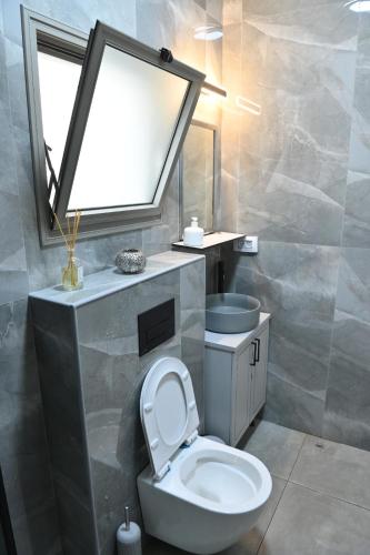 a bathroom with a white toilet and a sink at פסגת יובלים 2 in Qiryat Shemona