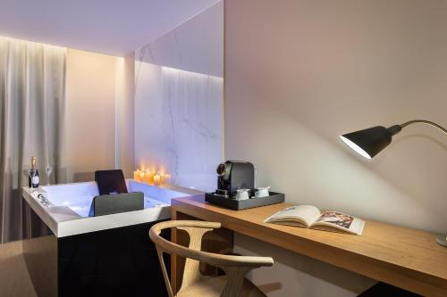 a room with a desk with a lamp and a book at 9Hotel Paquis in Geneva