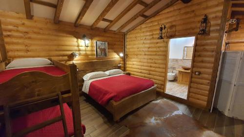 een slaapkamer met 2 bedden in een blokhut bij B&B Chalet in Abetone