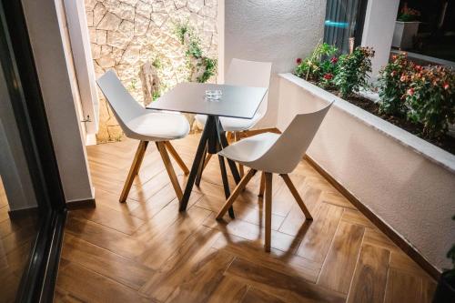 a table and chairs in a room with a window at Giardino Lux Apartments in Ulcinj
