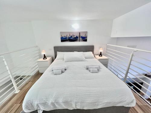 uma grande cama branca num quarto com 2 candeeiros em Pregevole loft con soppalco em Turim