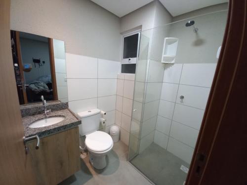 a bathroom with a toilet and a sink and a shower at Apartamento Paz e Traquilidade na praia in Luis Correia
