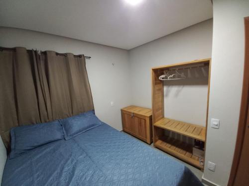 1 dormitorio con cama azul y espejo en Apartamento Paz e Traquilidade na praia, en Luís Correia