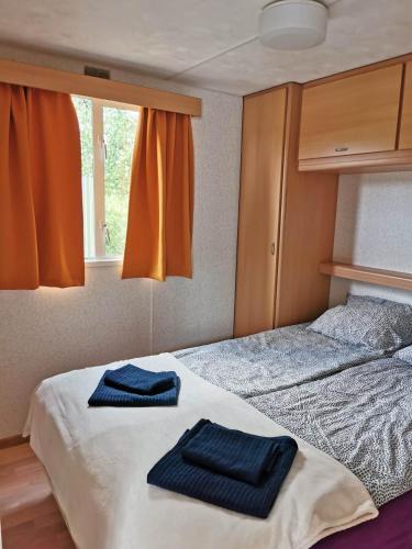 a bedroom with two towels sitting on a bed at Keja Domki Chłapowo in Władysławowo