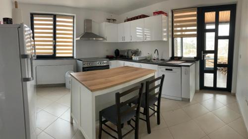 une cuisine avec des placards blancs et un comptoir en bois dans l'établissement Vila Dorna Royal, à Şarul Dornei