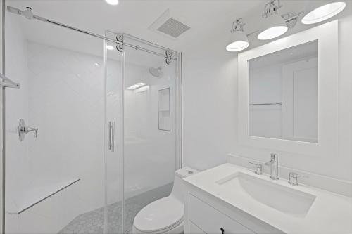 a bathroom with a shower and a toilet and a sink at Inviting condo with pool just a steps from the beach in Marco Island