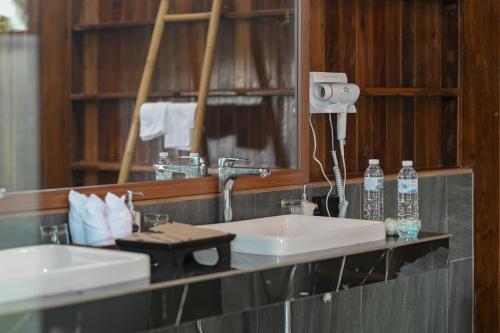 a bathroom with two sinks and a mirror at Pan's farm แบ่งปันฟาร์ม in Ban San Phaya Loei Luang
