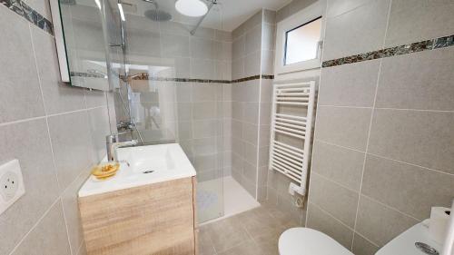 a bathroom with a sink and a toilet and a shower at Maison de vacances proche du Port in Saint-Gilles-Croix-de-Vie